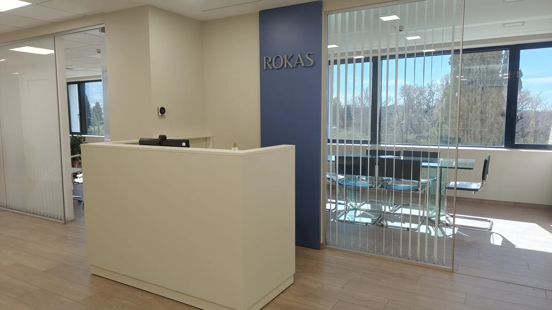Reception Rokas Law Firm με βαθύ μπλε brand wall και φυσικό φως